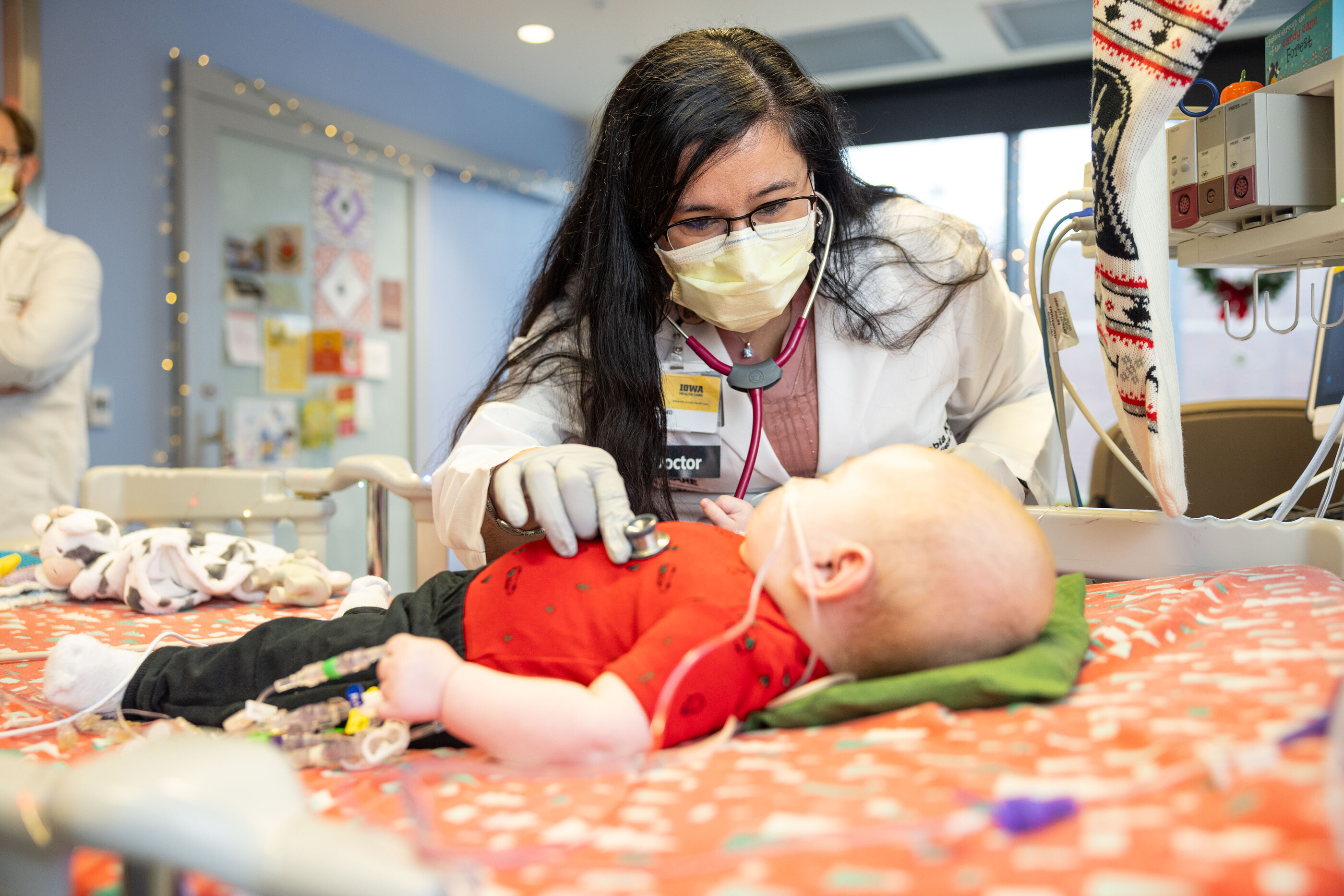 A pediatric cardiologist examines a baby who received a heart transplant. 