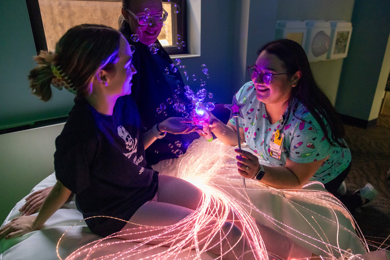 Medical assistant Lizeth DeLeon uses distraction items with a simulated patient (employee) in the comfort room at the Center for Disabilities and Development at University of Iowa Stead Family Children’s Hospital on Wednesday, Aug. 23, 2023.