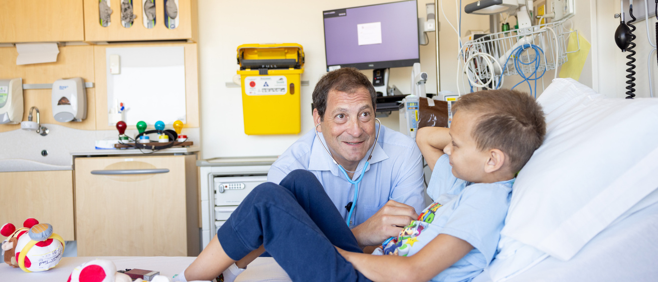 Pediatric oncology patients and care team at University of Iowa Stead Family Children’s Hospital on Tuesday, Aug. 15, 2023. Consent forms on file. Dr. David Dickens with patient in infusion room