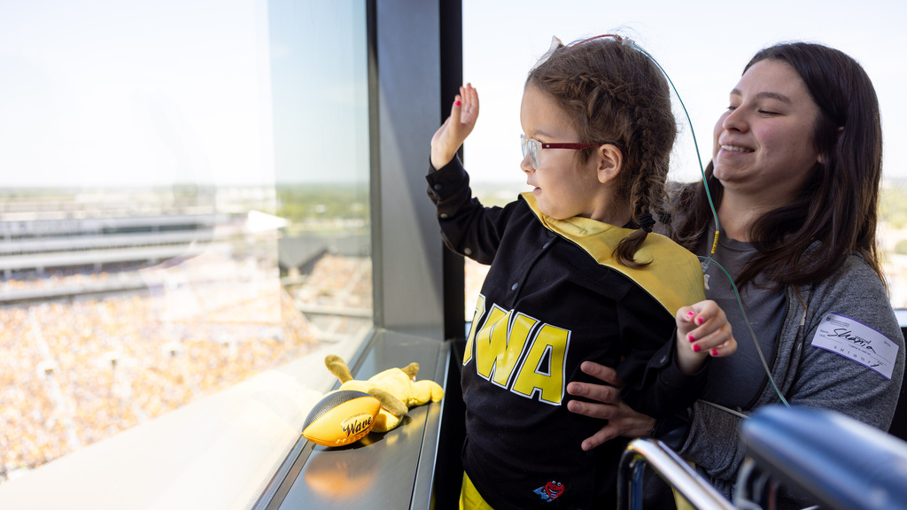 Patients and their family members wave to Hawkeye football fans from University of Iowa Stead Family Children’s Hospital on Saturday, Sept. 2, 2023.